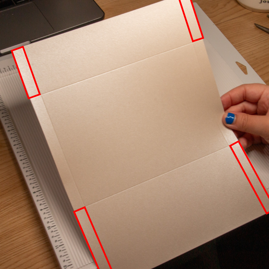 Cardstock showing 4 red boxes in the corners of the cardstock to show where to cut the cardstock