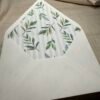an A7 white envelope with green leaves on it